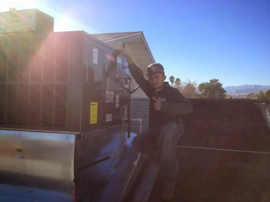 HVAC technician performing HVAC Inspection on a rooftop unit in Hampton